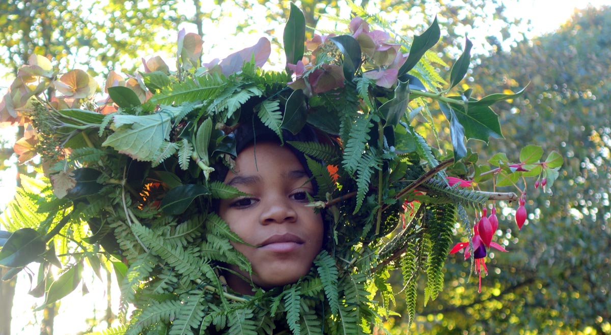 A young boy wearing a majestic garland.