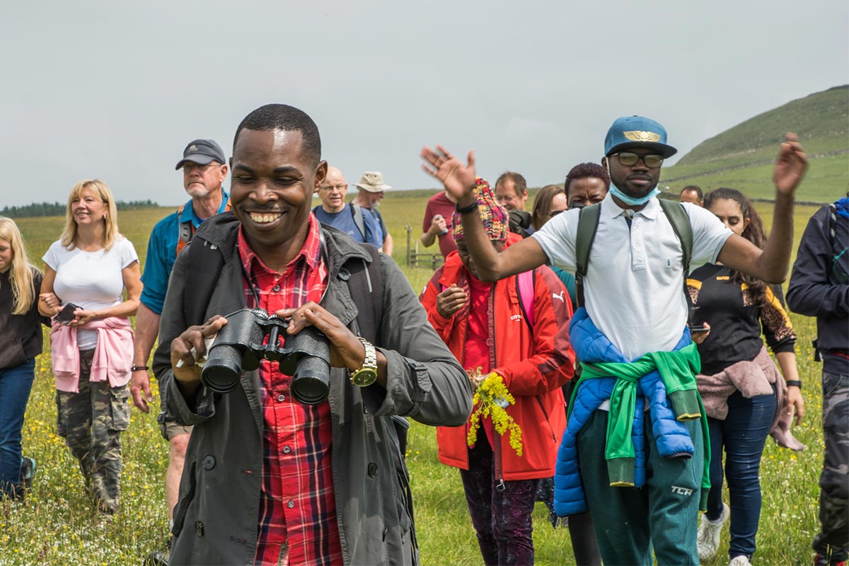 A joyful group walking together in Northumberland National Park.