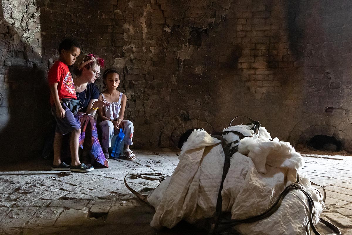 A woman with two kids looking at the art installation.